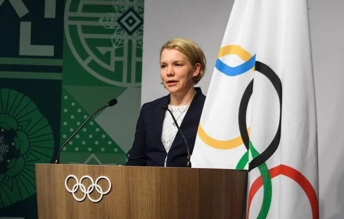 Emma Terho speaking beside the Olympic flag